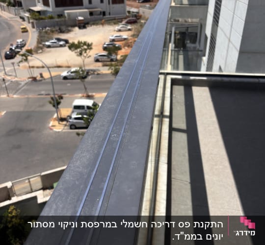מעקה מרפסת עם נוף לבניינים ושכונה